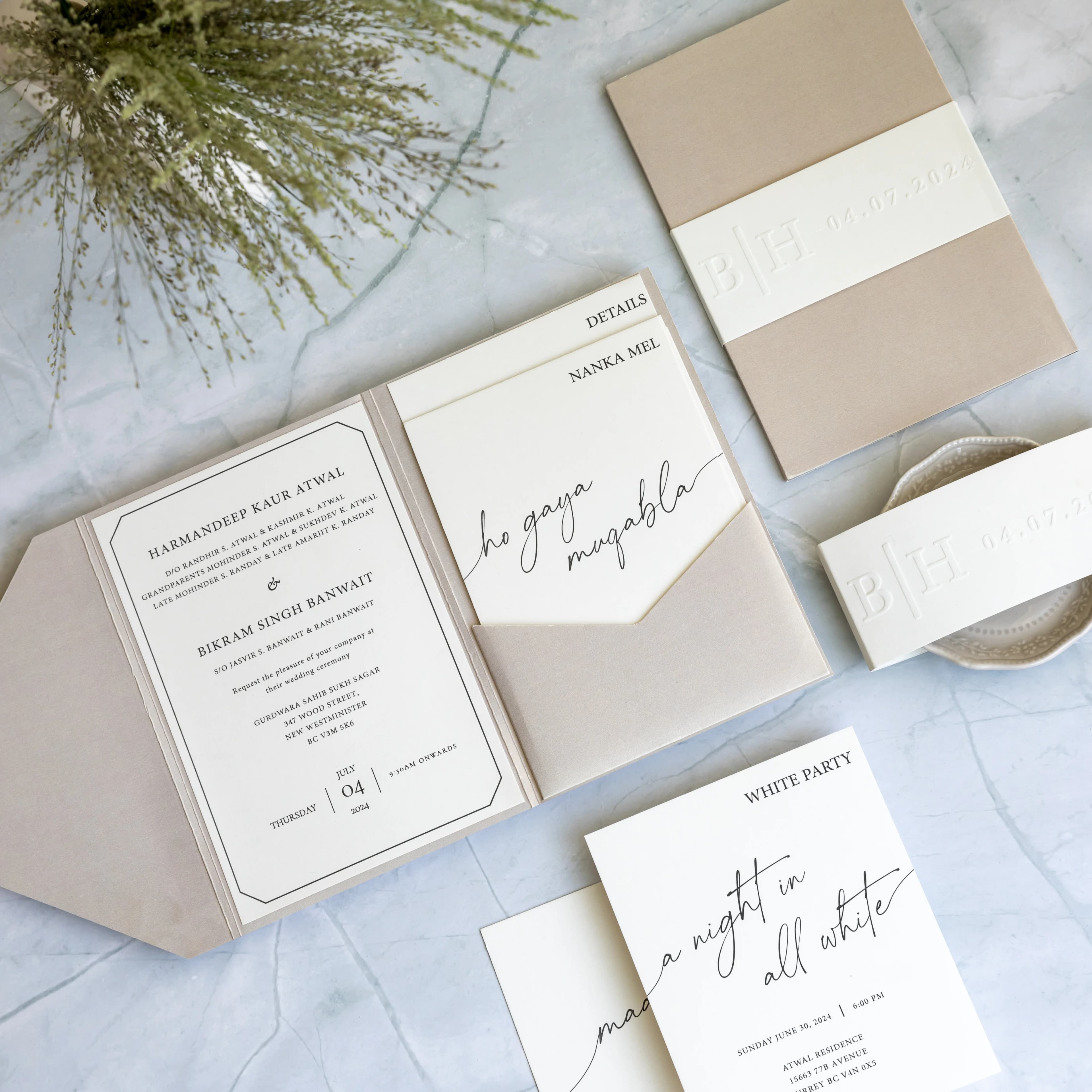 Flat lay of bespoke wedding invitations with gold floral detailing, roses and silk ribbon